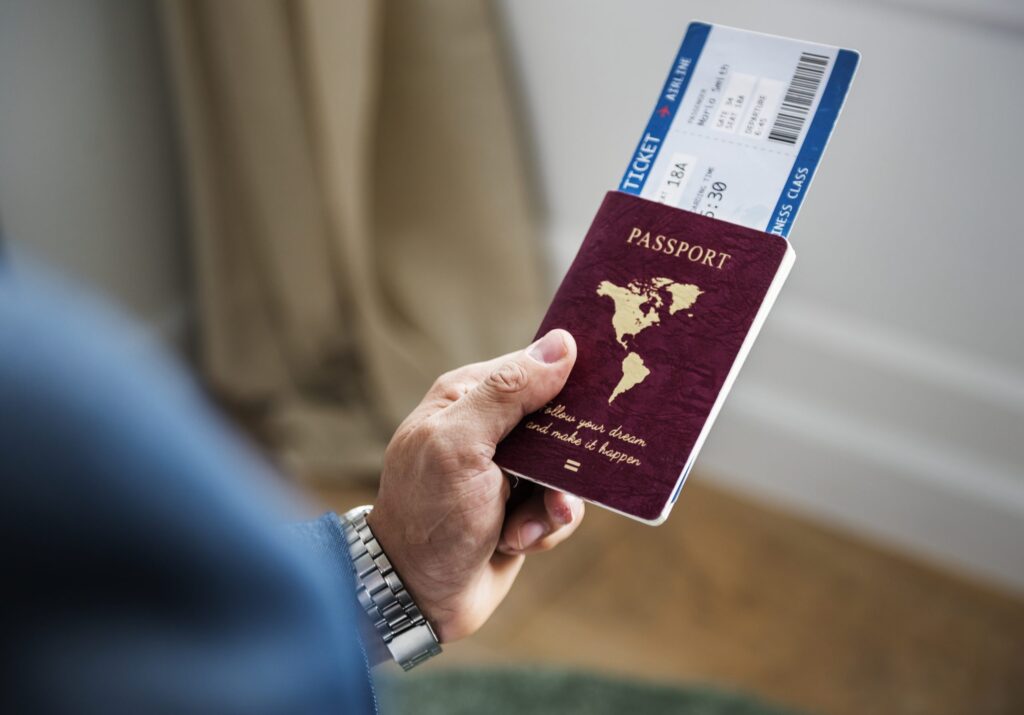 Passaporte vermelho, imagem da mão de um homem segurando um passaporte vermelho