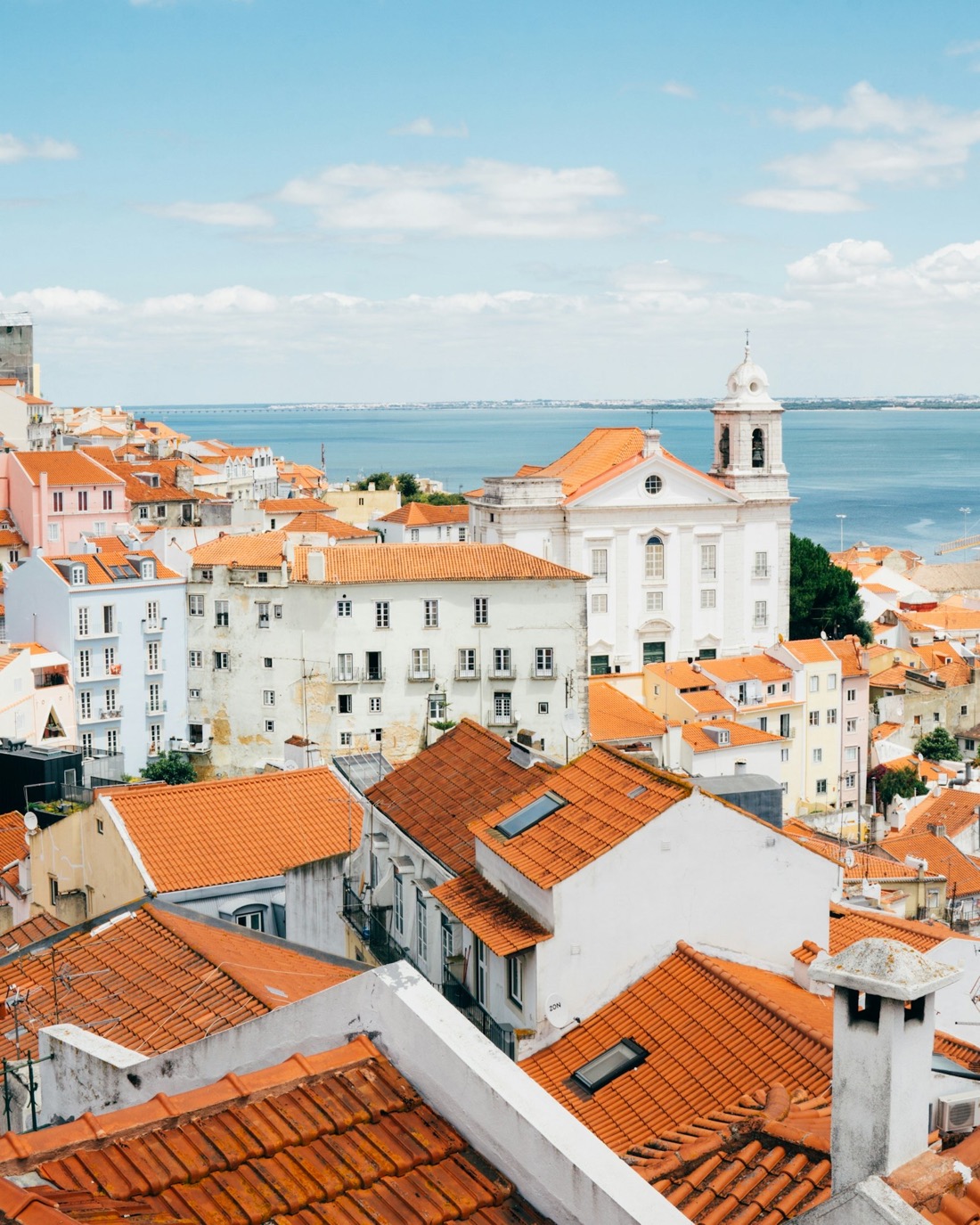 Telhados do bairro de Alfama com o Rio Tejo ao fundo, em Lisboa, Portugal